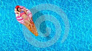 Woman in bikini on the inflatable mattress in the swimming pool.