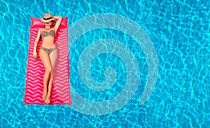 Woman in bikini on the inflatable mattress in the swimming pool.