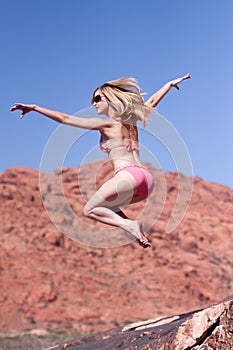 Woman in bikini jumping outdoors