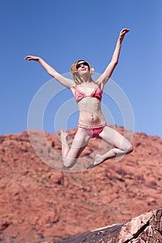 Woman in bikini jumping outdoors