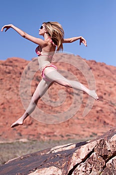 Woman in bikini jumping outdoors