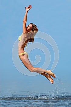 Woman in bikini jumps out of water