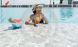 A woman in a bikini lounge by a poolside, sunbathing and relaxing on a sunny day