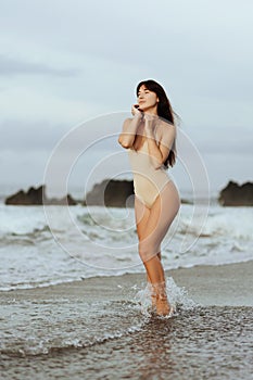 Woman in bikini posing behind blue ocean