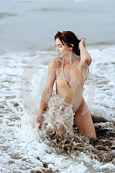 Woman in bikini posing behind blue ocean