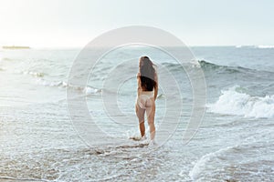 Woman in bikini posing behind blue ocean