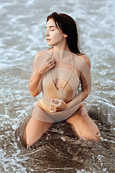 Woman in bikini posing behind blue ocean