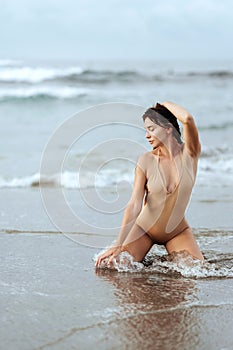 Woman in bikini posing behind blue ocean