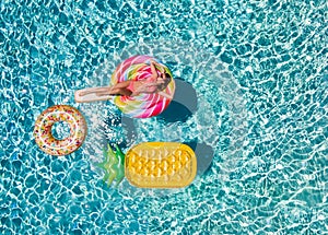 Woman in bikini relaxes on a lolli pop shaped swimming pool float