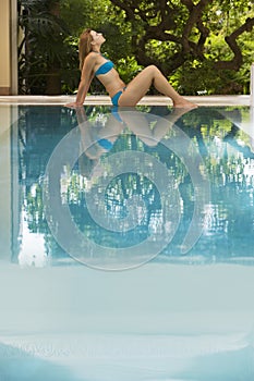 Woman In Bikini Relaxing By Swimming Pool