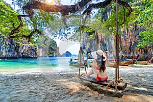 Woman in bikini relaxing on swing at Ko lao lading island, Krabi, Thailand photo