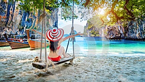 Woman in bikini relaxing on swing at Ko lao lading island, Krabi, Thailand photo