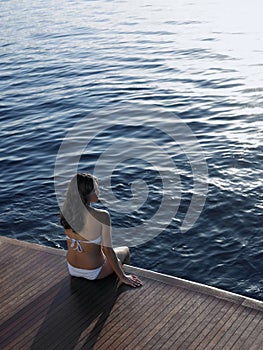 Woman In Bikini Relaxing On Yacht's Floorboard