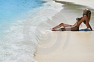 Woman in bikini sunbathing on beach