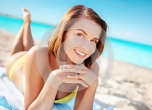 Woman in bikini sunbathing on beach