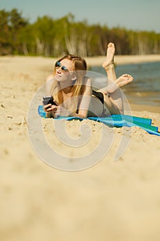 Woman in bikini sunbathing and relaxing on beach