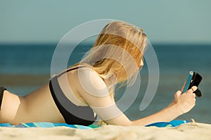 Woman in bikini sunbathing and relaxing on beach