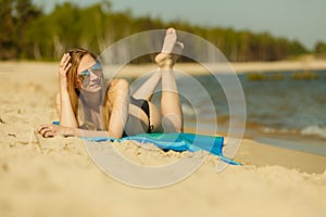 Woman in bikini sunbathing and relaxing on beach