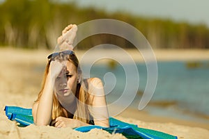 Woman in bikini sunbathing and relaxing on beach