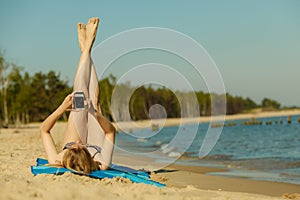 Woman in bikini sunbathing and relaxing on beach