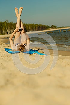 Woman in bikini sunbathing and relaxing on beach