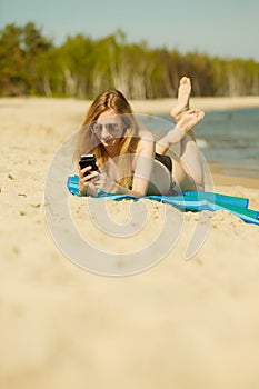 Woman in bikini sunbathing and relaxing on beach