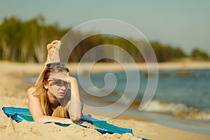 Woman in bikini sunbathing and relaxing on beach