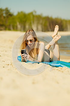 Woman in bikini sunbathing and relaxing on beach