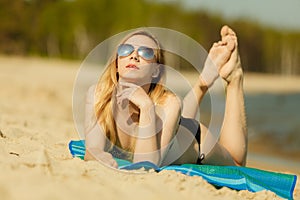 Woman in bikini sunbathing and relaxing on beach