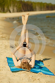 Woman in bikini sunbathing and relaxing on beach