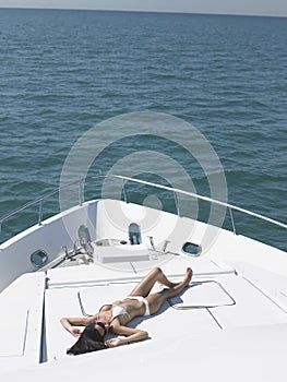 Woman In Bikini Sunbathing On Yacht