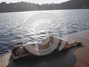 Woman In Bikini Sunbathing On Yacht's Floorboard