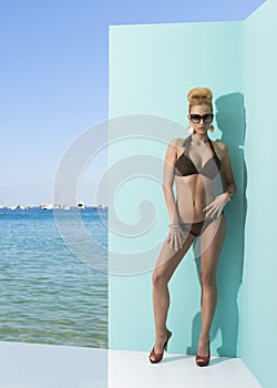 Woman in bikini with sunglasses and hand on the hip