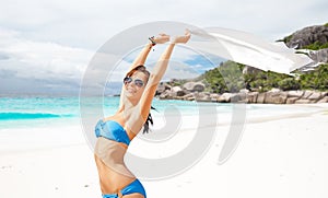 Woman in bikini and sunglasses with pareo on beach