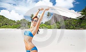 Woman in bikini and sunglasses with pareo on beach