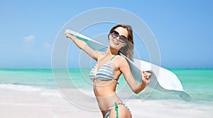 Woman in bikini and sunglasses with pareo on beach