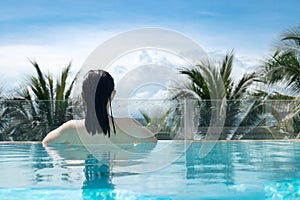 woman in bikini swimming suit relaxing in the luxury pool