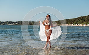 woman in bikini swimsuit with cover-up on beach