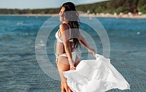 woman in bikini swimsuit with cover-up on beach