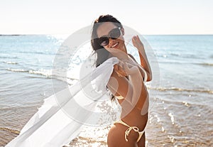 woman in bikini swimsuit with cover-up on beach