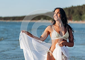 woman in bikini swimsuit with pareo on beach