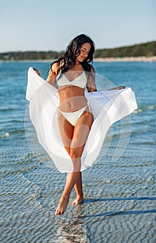 woman in bikini swimsuit with pareo on beach