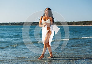 woman in bikini swimsuit with pareo on beach