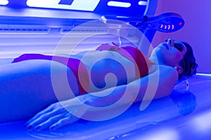 Woman in bikini tanning in wellness spa