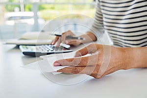 Woman with bills and calculator. Woman using calculator to calculate bills at the table in office. Calculation of costs.