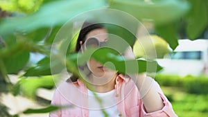 Woman with binoculars hiding behind trees, journalist searching for sensation