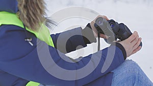 Woman with binoculars sitting in forest