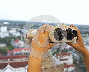 Woman with binoculars and telescope on tower concept travel and explore the surrounding city