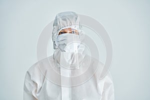 Woman in bio-hazard suit and face shield on white background.