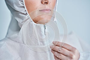 Woman in bio-hazard suit on white background.